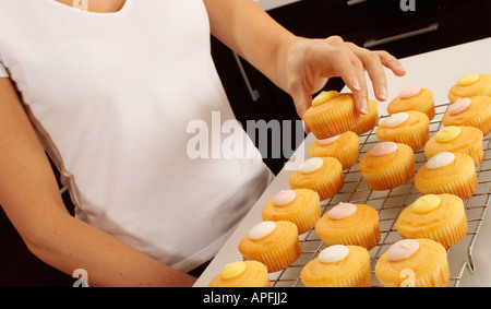 WOMAN BAKING CUPCAKES DANS LA CUISINE Banque D'Images