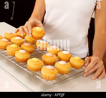 WOMAN BAKING CUPCAKES DANS LA CUISINE Banque D'Images