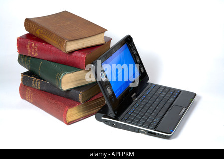 Une pile de livres de poésie et un mini-ordinateur portable sur un fond blanc. Banque D'Images