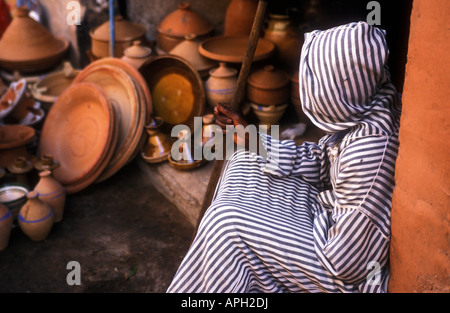 Un homme dans un bar d'djelaba repose sur son voyage à travers le labyrinthe de boutiques et d'échoppes dans les souks de Marrakech Banque D'Images