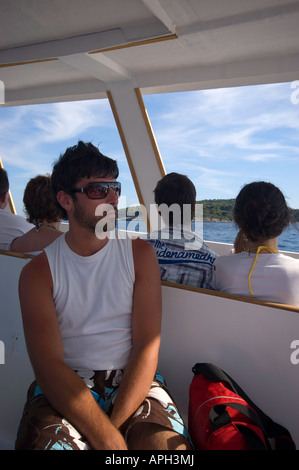 Jeune homme voyageant en bateau pour l'île de Sipan Banque D'Images