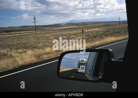 Vue de derrière le siège du conducteur de camion dans le rétroviseur sur la route près de Moab Utah avec la distance en montagnes LaSal Banque D'Images