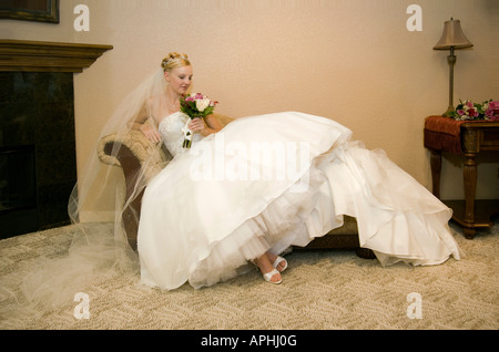 Se prélasser mariée ou d'attente avant le mariage dans tout le corps de la table canapé chaise 'portrait' des coups de se préparer Banque D'Images