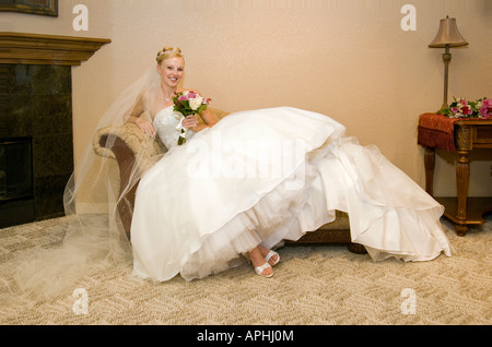 Se prélasser mariée ou d'attente avant le mariage dans tout le corps de la table canapé chaise 'portrait' des coups de se préparer Banque D'Images