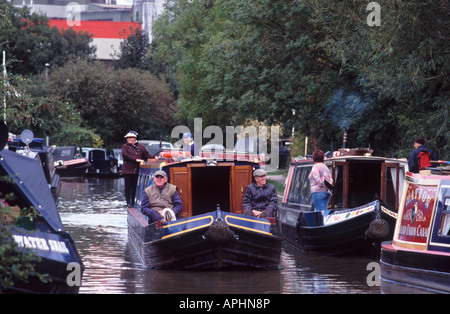 Deux smiling mature, assis sur le pont avant d'un grand classique avec deux femmes souriant à la barre, Banbury Oxfordshire, Angleterre Banque D'Images