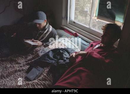 Les jeunes vivant dans le sud de Londres, l'accroupissement lying on bed, à écouter des CD. Banque D'Images