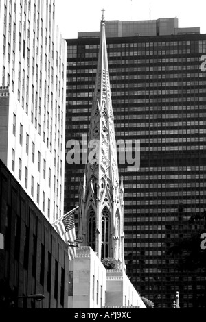 Une flèche de la cathédrale Saint Patrick, contraste du noir et blanc à la modernité laïque, les immeubles de bureaux de la ville de New York. Banque D'Images