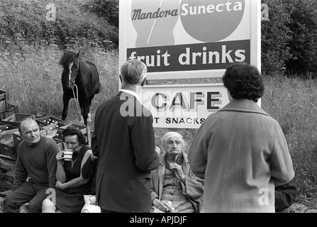 Sortie en famille des années 1970 buvant une tasse de thé sous l'extérieur sous un panneau de café. Matlock Derbyshire 1970 Royaume-Uni. HOMER SYKES Banque D'Images