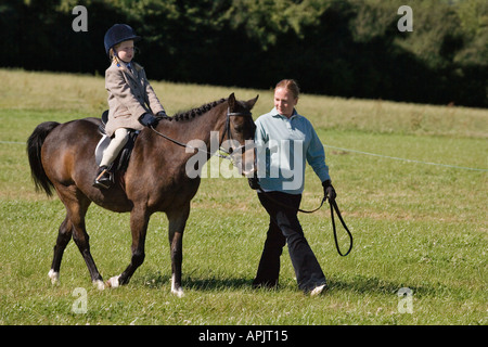 Petite fille âgée de huit ÉQUITATION ÉQUITATION PONEY DANS OUTFIT VÊTEMENTS AVEC DES PROFILS PRINCIPAUX PONY UK Banque D'Images