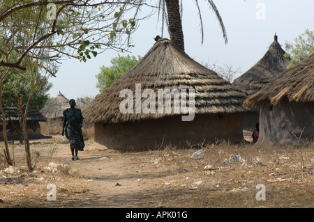 Femme marche a adopté une hutte traditionnelle dans le sud du Soudan, l'Afrique Banque D'Images