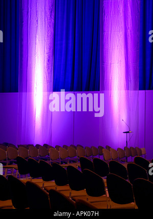 La salle de conférence avec des rangées de chaises rideaux tentures bleu violet microphones Banque D'Images