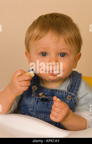 Bébé garçon 10 mois eating fruit Banque D'Images