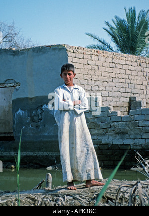 Nassiriyah IRAK Jeune garçon iraquien en vêtements traditionnels se tenait devant sa maison en brique d'adobe sur l'Euphrate Banque D'Images