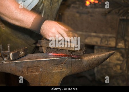 L'ILLINOIS Grand Détour de la main à l'aide d'une brosse en acier forge fer chaud sur l'enclume, site historique de John Deere Banque D'Images
