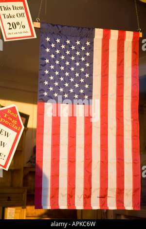 Dixon ILLINOIS drapeau américain suspendu dans des affiches de fenêtre pour red tag spécial dans un magasin de détail des prix bas Banque D'Images