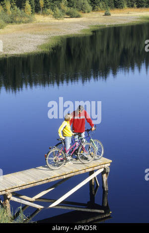 Jeune couple avec des vélos sur une promenade au bord d'un lac, l'Autriche, Alpes Banque D'Images