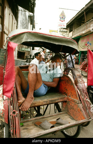 Java Indonésie Yogjakarta chauffeur endormi dans son cycle rickshaw becak Banque D'Images