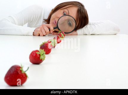 Jeune femme se loupe sur une ligne de fraises Banque D'Images