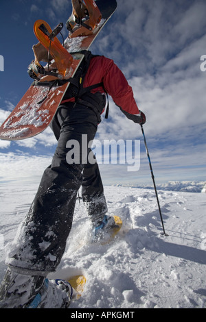 Man with snowboard sur le dos à la raquette, Autriche Banque D'Images
