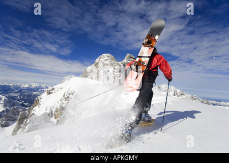 Man with snowboard sur le dos à la raquette, Autriche Banque D'Images