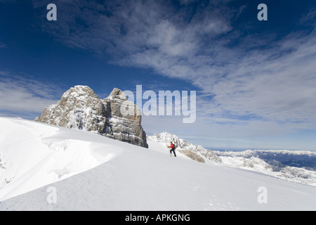 Man with snowboard sur le dos à la raquette dans les montagnes, Autriche Banque D'Images