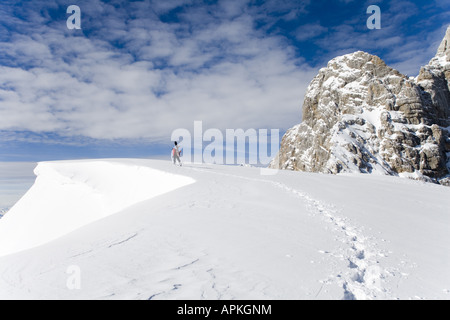 Man with snowboard sur le dos à la raquette dans les montagnes, Autriche Banque D'Images