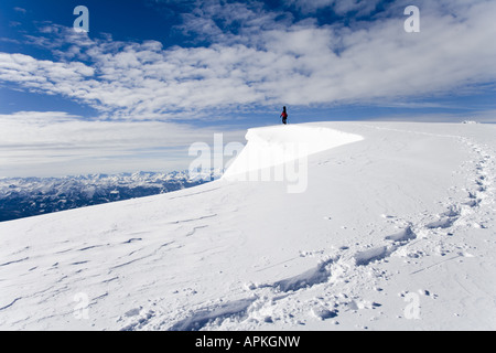Man with snowboard sur le dos à la raquette dans les montagnes, Autriche Banque D'Images