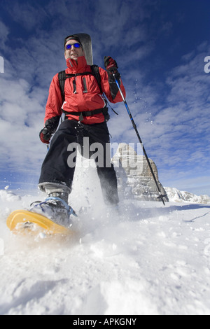 Man with snowboard sur le dos à la raquette dans les montagnes, Autriche Banque D'Images