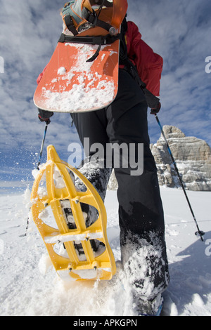 Man with snowboard sur le dos à la raquette dans les montagnes, Autriche Banque D'Images
