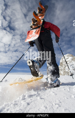 Man with snowboard sur le dos à la raquette dans les montagnes, Autriche Banque D'Images