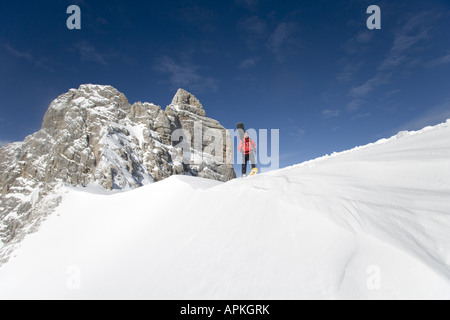 Man with snowboard sur le dos à la raquette dans les montagnes, Autriche Banque D'Images