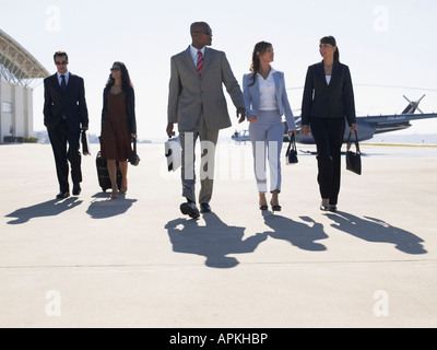 Cinq businesspeople walking at airport Banque D'Images