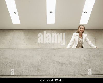 Businesswoman leaning against wall (portrait, low angle view) Banque D'Images