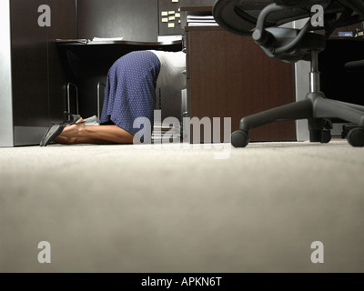 Female office worker genoux sous 24 Banque D'Images