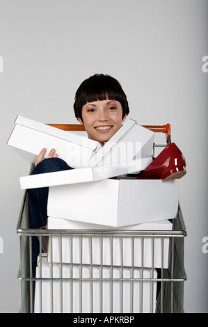 Femme avec des boîtes à chaussures dans le panier Banque D'Images