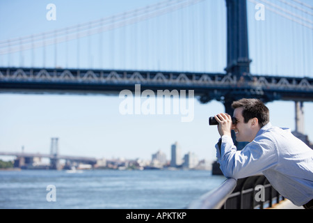 L'homme à l'aide de jumelles à proximité de Pont de Brooklyn, New York City, New York, USA Banque D'Images