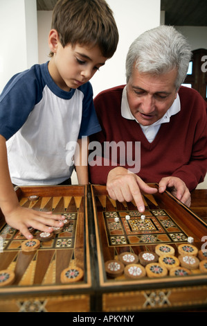 Grand-père et petit-fils jouant au backgammon Banque D'Images