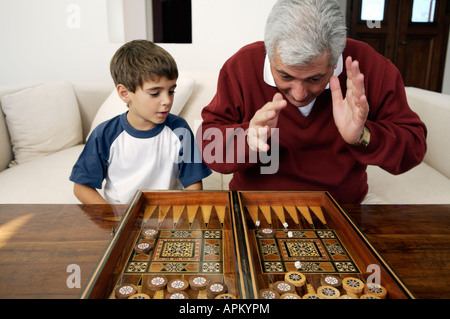 Grand-père et petit-fils jouant au backgammon Banque D'Images