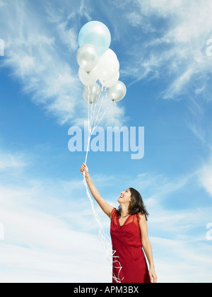 Mid adult woman holding balloons Banque D'Images