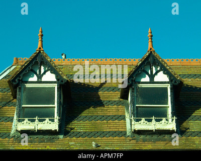 WANTAGE, Oxon, UK. 13 novembre 2004. Dans le besoin de peinture, les lucarnes avec des tuiles décoratives et se percher pigeon. Ciel bleu clair Banque D'Images