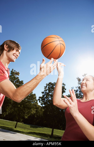 La femme et l'homme de tourner sur le doigt de basket-ball Banque D'Images