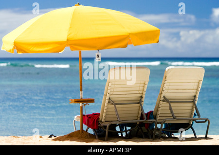 Chaises de plage sous parapluie jaune vif Waikiki Beach Honolulu Hawaii USA Banque D'Images