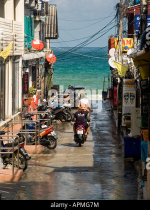 Motos sur routes mouillées de Hat Rin village après une douche tropicale Ko Pha Ngan Thaïlande Banque D'Images