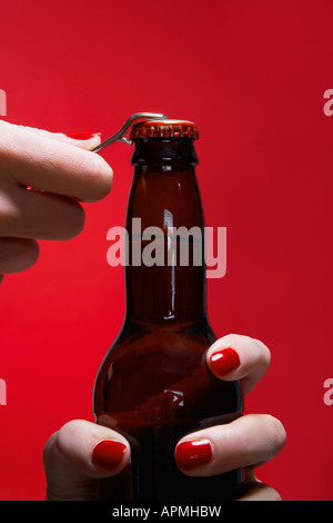 Young woman's hands opening bottle of beer (close-up) Banque D'Images