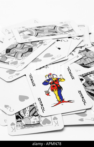 Le noir et blanc des jeux de cartes sur un fond blanc avec couleur bleu rouge vif sélectivement carte joker sur le dessus de la pile Banque D'Images