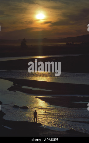 Un homme sur le Tesiin Ged du fleuve au coucher du soleil. Le SEV somon. Zavkhan Province. Le nord-ouest de la Mongolie Banque D'Images