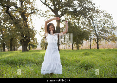 Teenage girl in white dress in field Banque D'Images