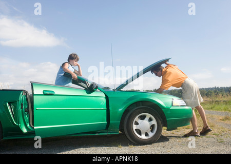 Père et fils aux prises avec panne de voiture Banque D'Images