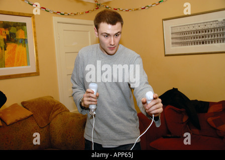 Un jeune homme jouant sur une console Nintendo Wii. Banque D'Images