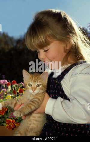 Young Girl holding tabby chaton jaune en jardin d'été Banque D'Images